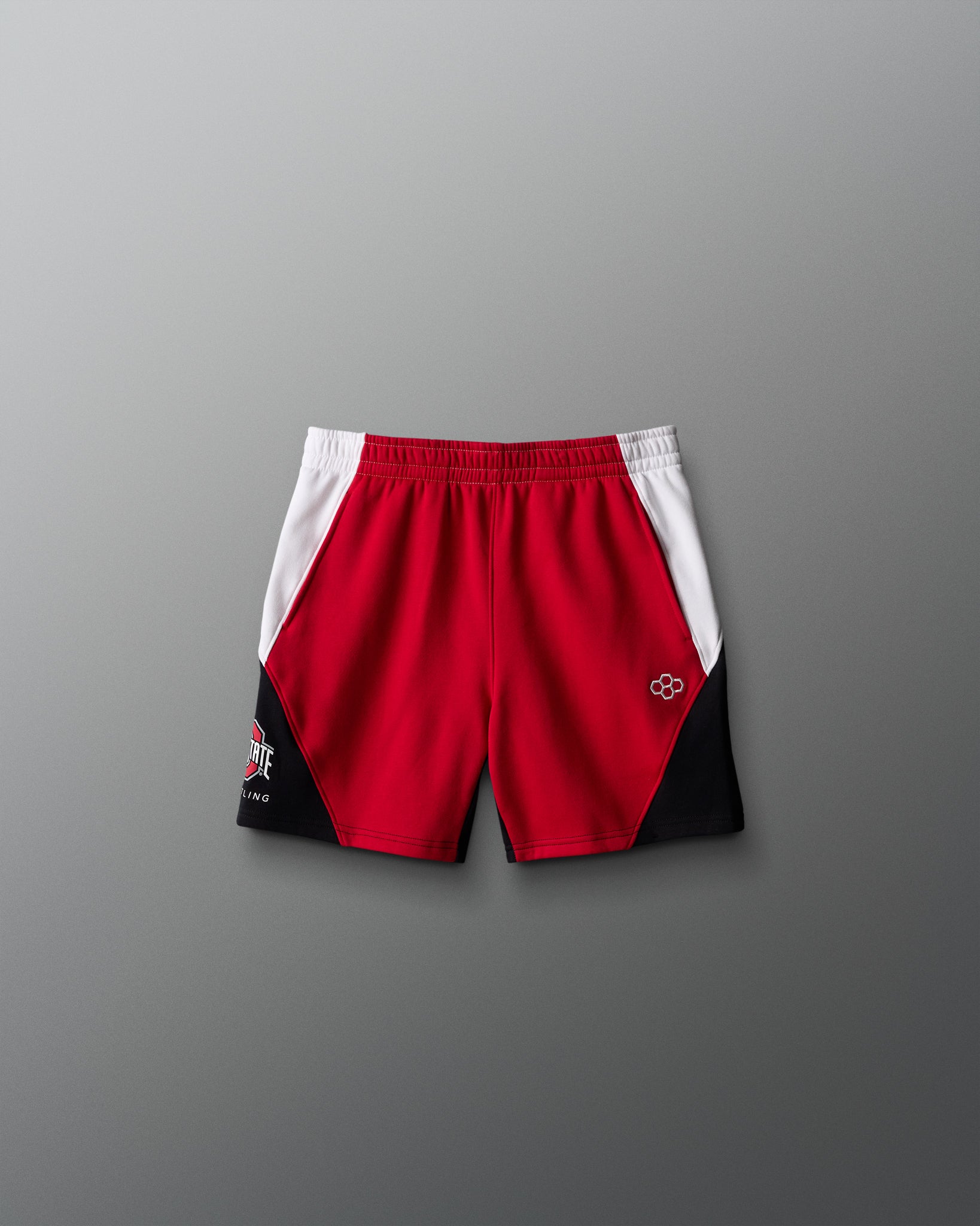 Red and black athletic shorts with a logo on a gray background