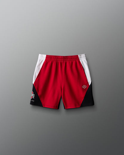 Red and black athletic shorts with a logo on a gray background
