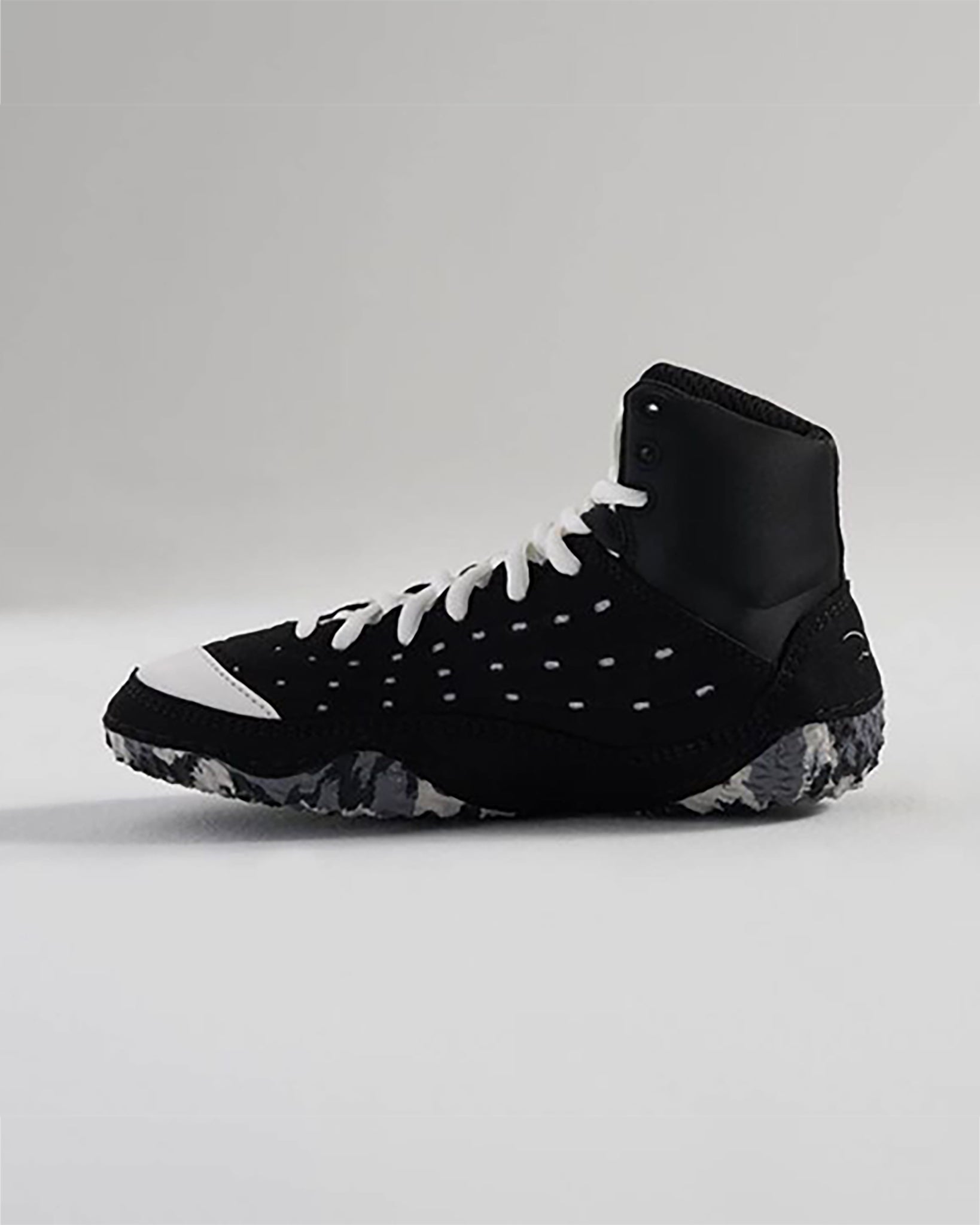 The image showcases a stylish black athletic shoe with distinctive white accents designed for both performance and aesthetics