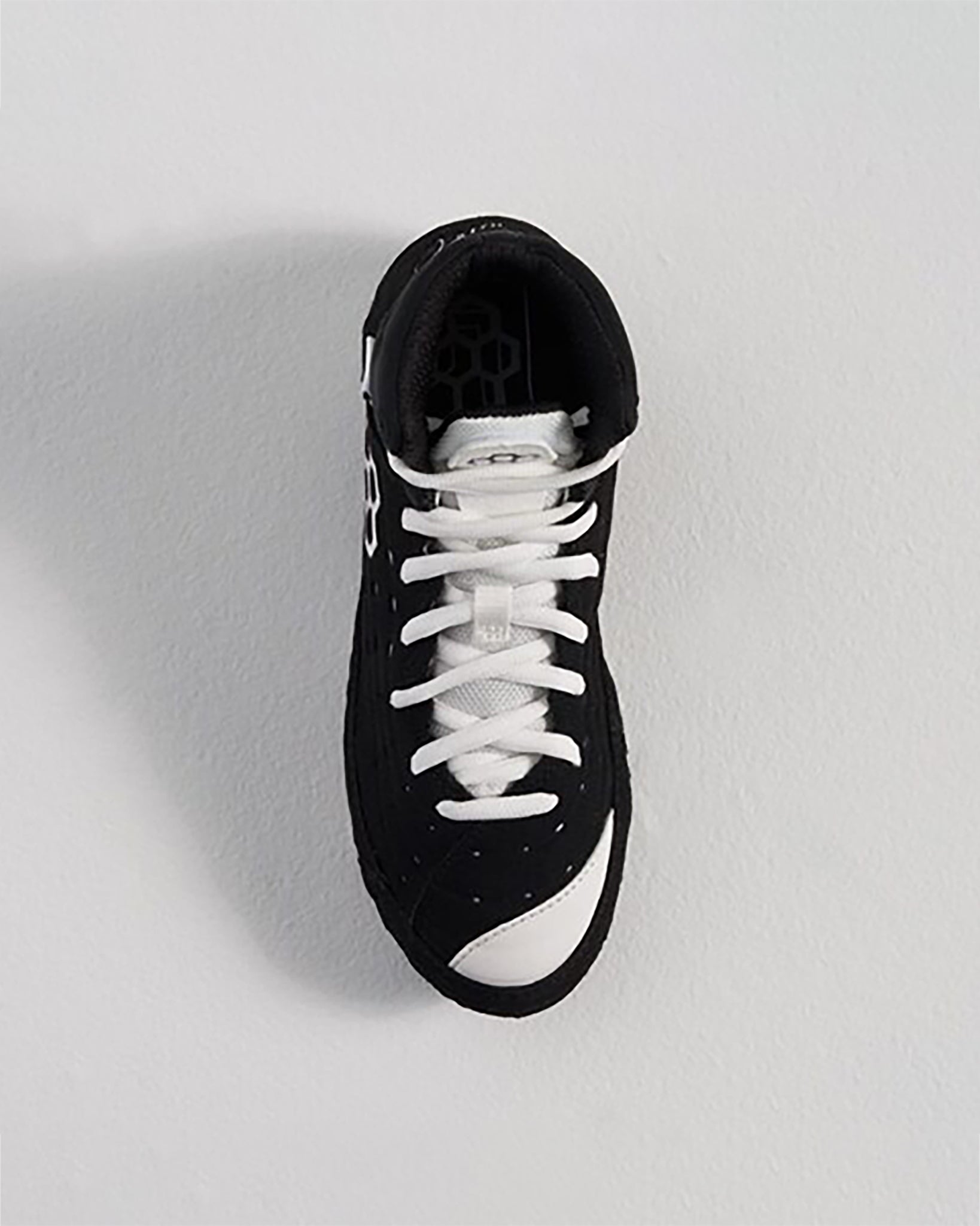 This image displays a black and white sneaker with a sleek design and textured details ideal for both sports and casual wear