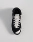 This image displays a black and white sneaker with a sleek design and textured details ideal for both sports and casual wear