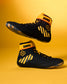 A pair of black high-top wrestling shoes with bright yellow accents, including the ankle collar, three diagonal stripes, a hexagonal logo, and the brand name 'KONG' printed on the collar, set against a solid yellow background.