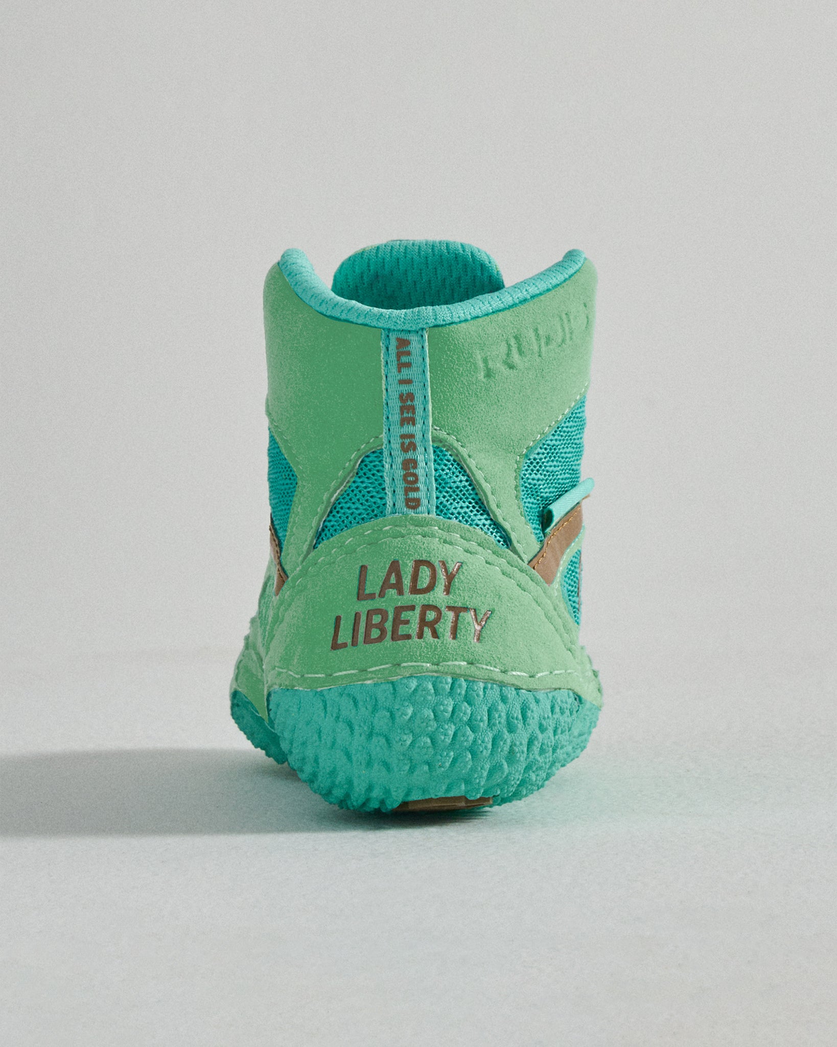 A vibrant turquoise athletic shoe featuring a unique design with the text LADY LIBERTY prominently displayed on the back