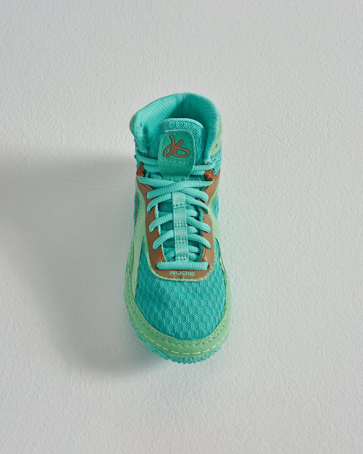 A top view of a turquoise athletic shoe with a textured sole and contrasting tan details designed for optimal performance and style