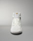 A high-top athletic shoe in white showcases a simple design with a gold logo on the tongue, set against a gradient background.