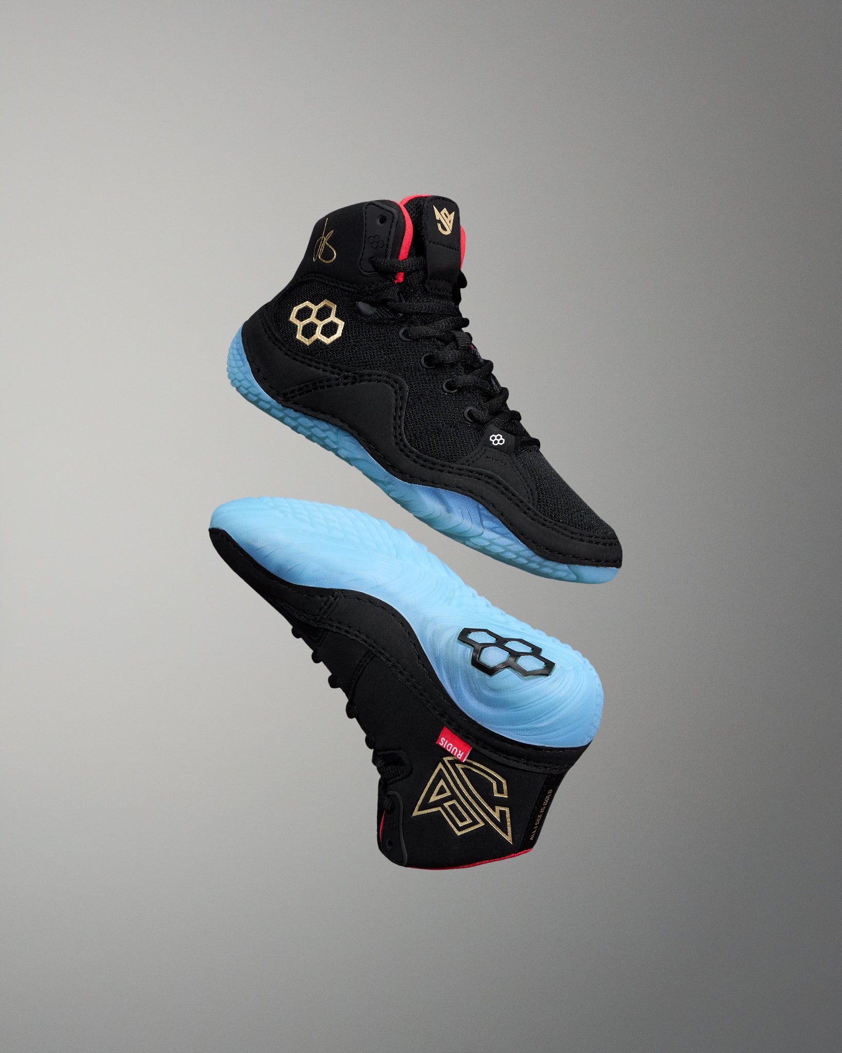 Black wrestling shoe with blue soles on a gray background