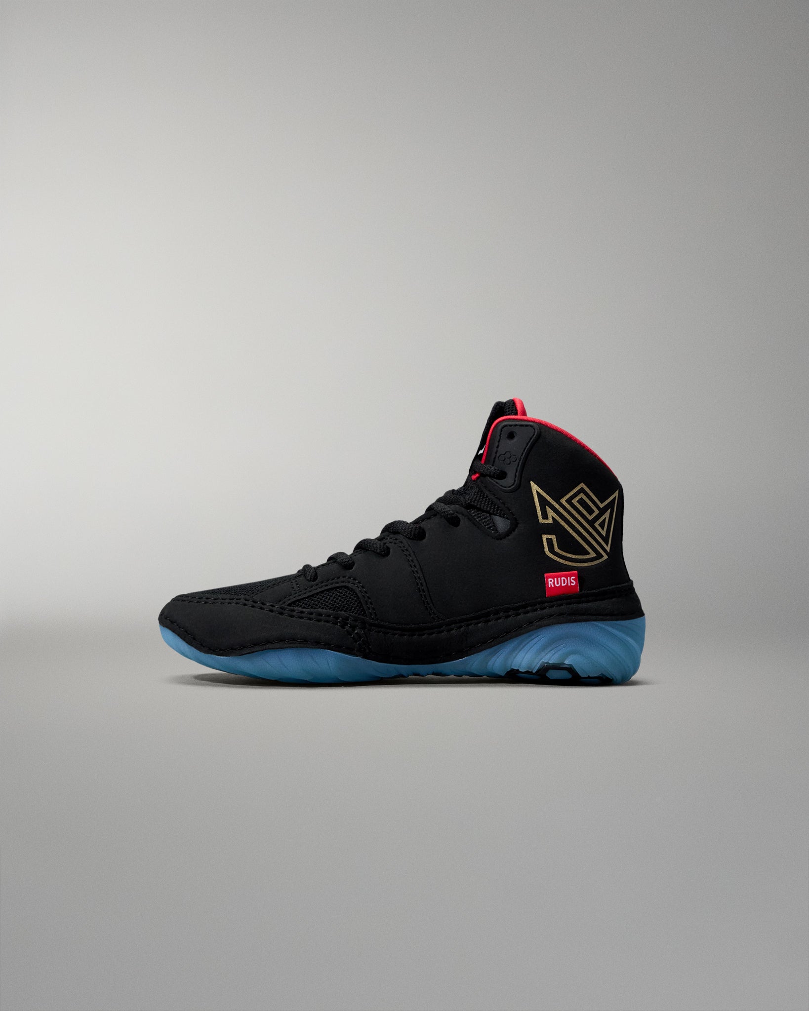 Black wrestling shoe with red and blue accents on a gray background