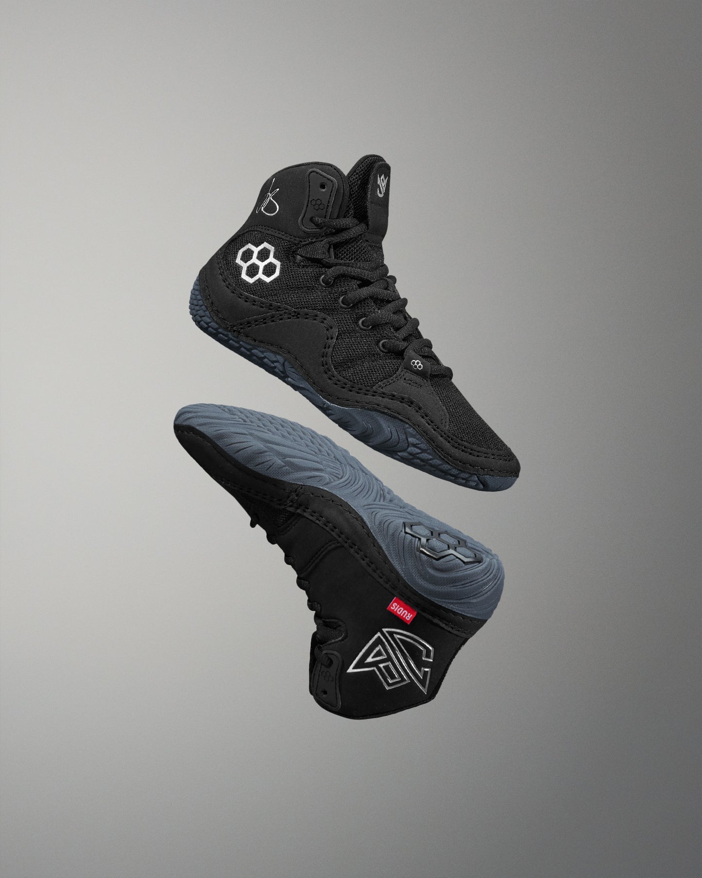 Black high-top wrestling shoe with brand logo on a gray background