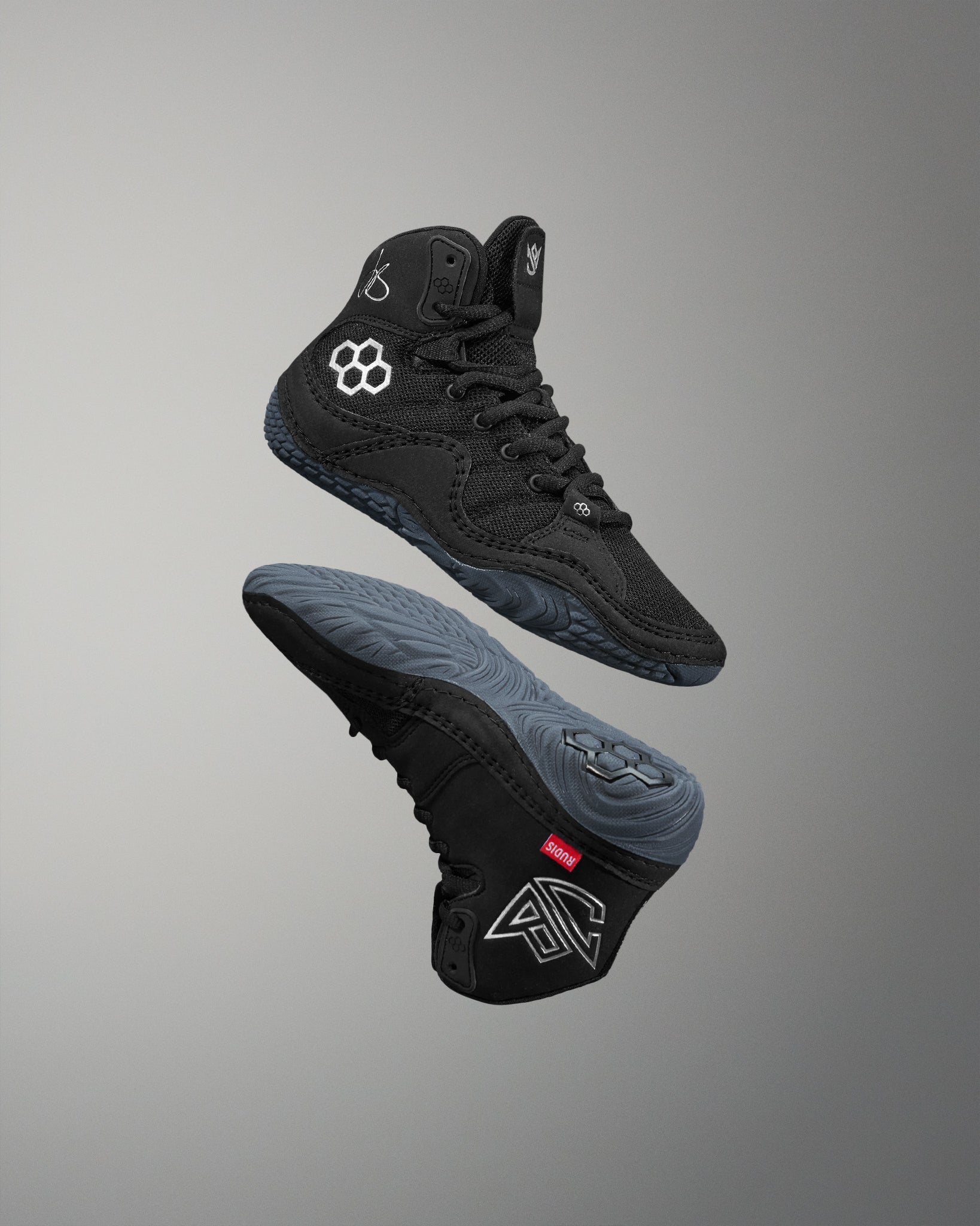 Black high-top wrestling shoe with brand logo on a gray background