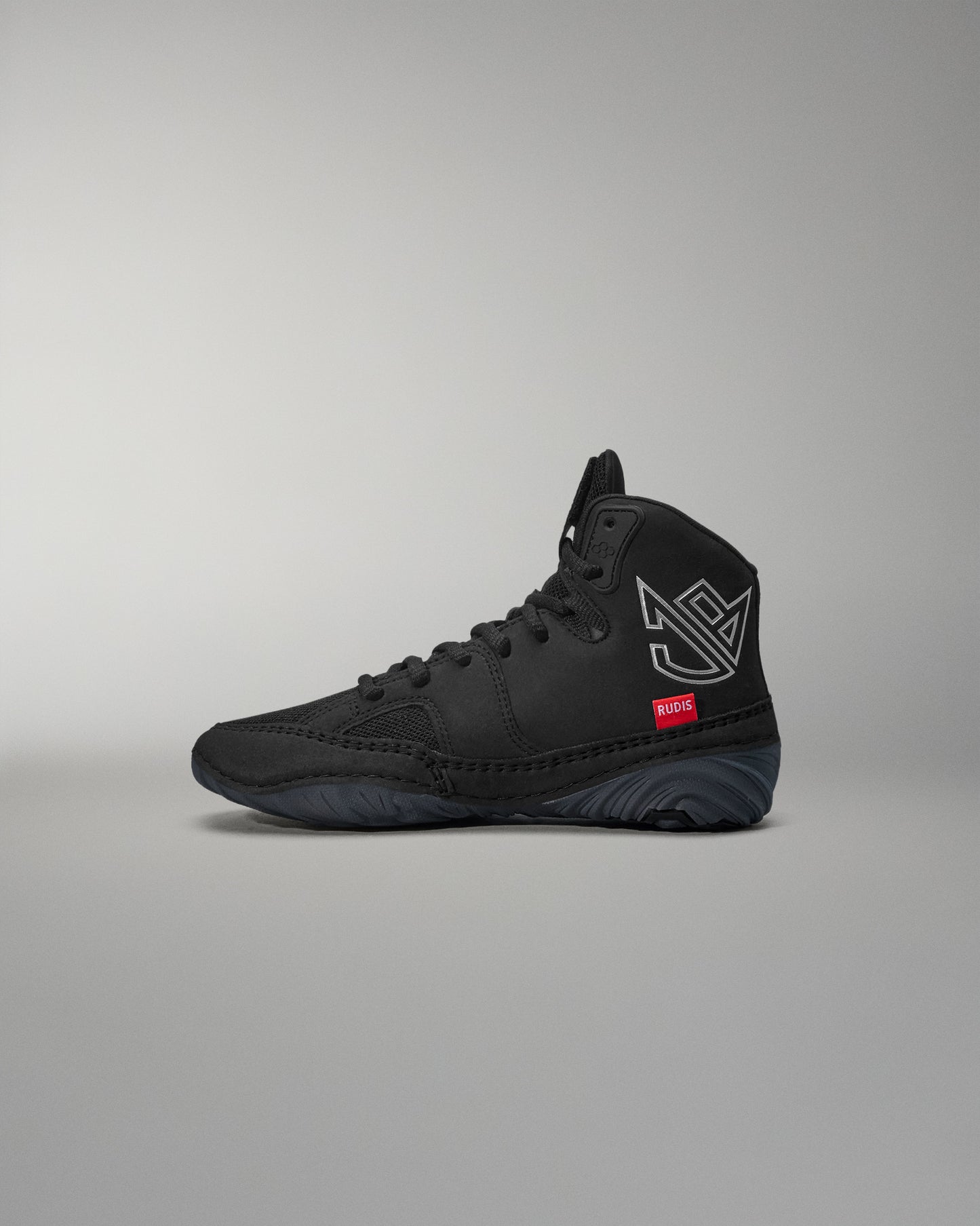 Black high-top wrestling shoe with a logo on a gray background