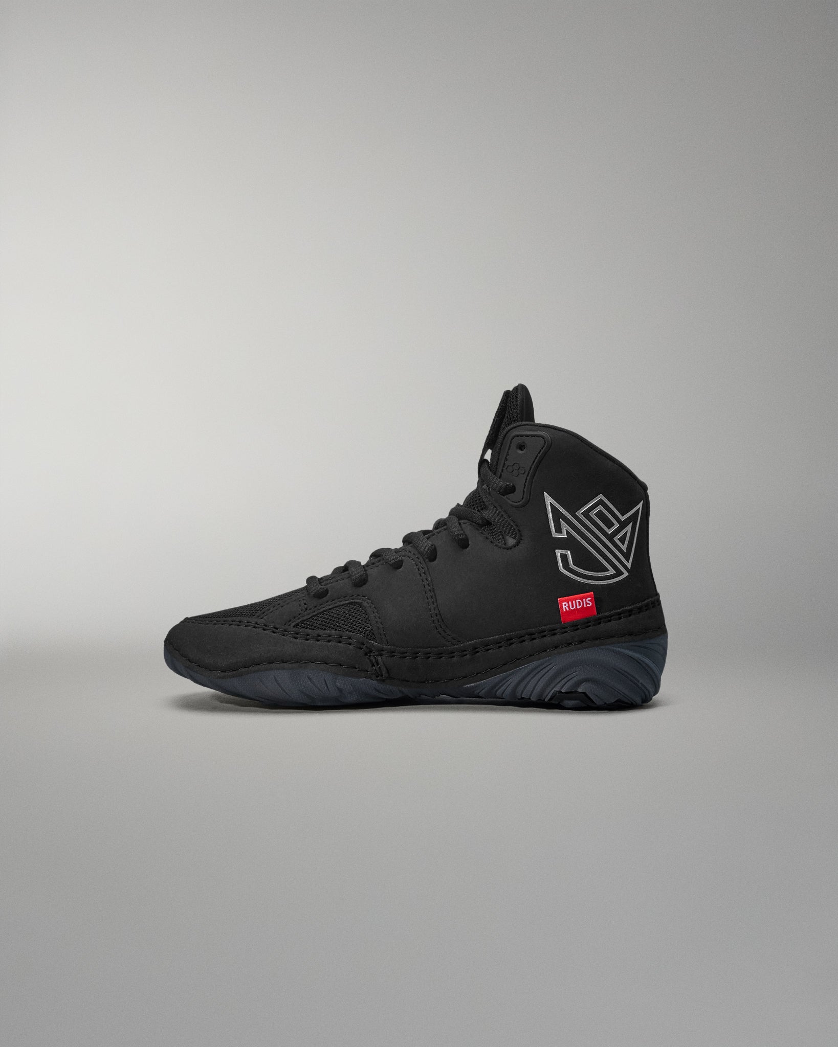Black high-top wrestling shoe with a logo on a gray background