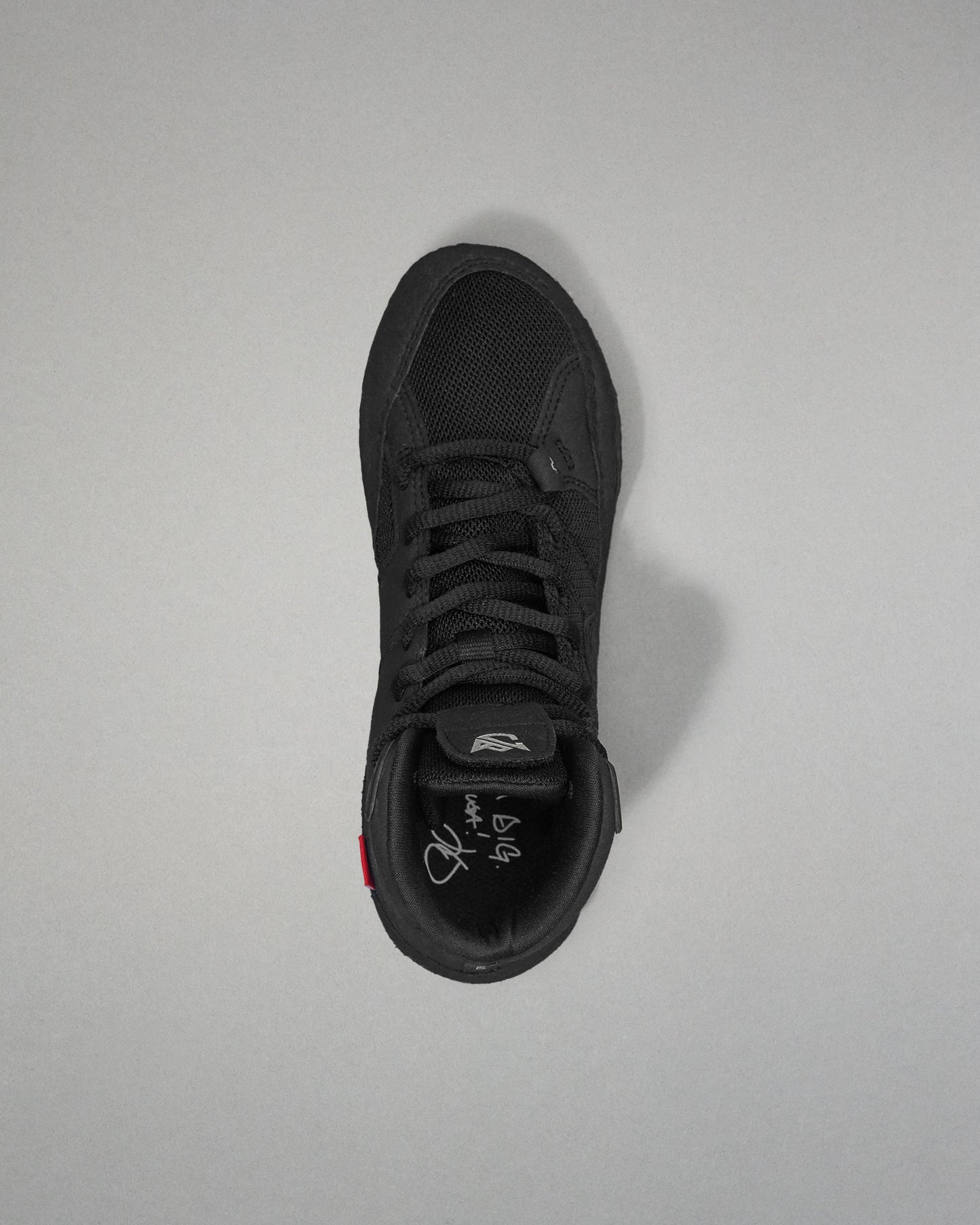 Black wrestling shoe on a light gray background