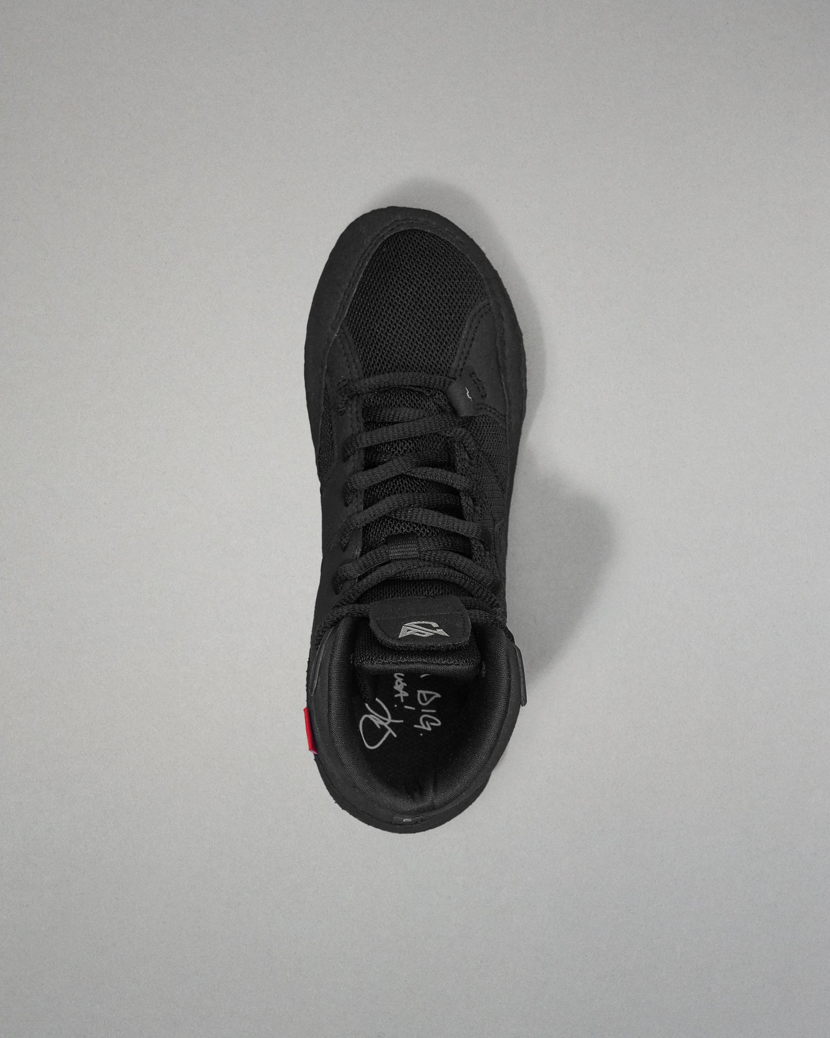 Black wrestling shoe on a light gray background