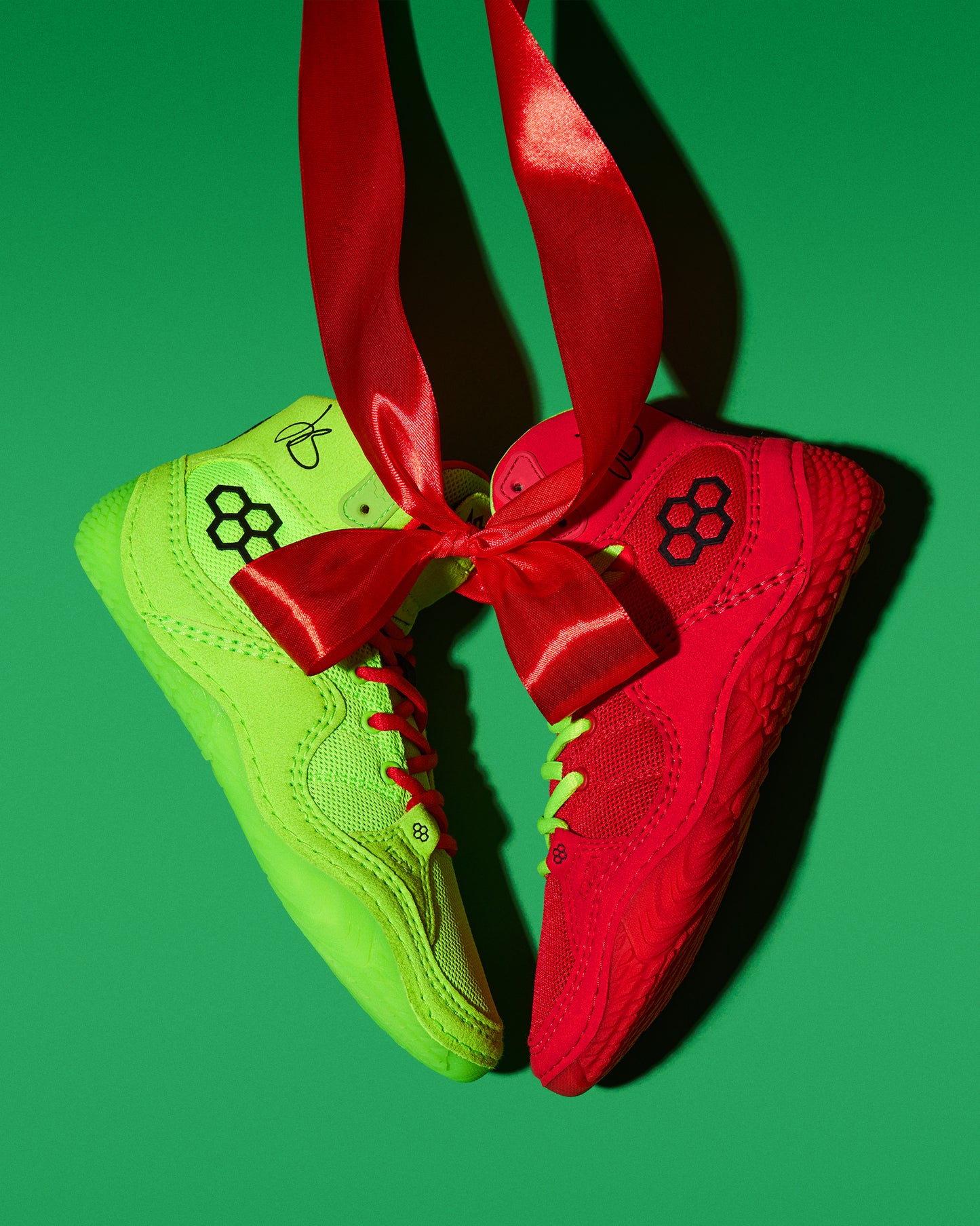 Green and red Wrestling shoes with a red ribbon on a green background