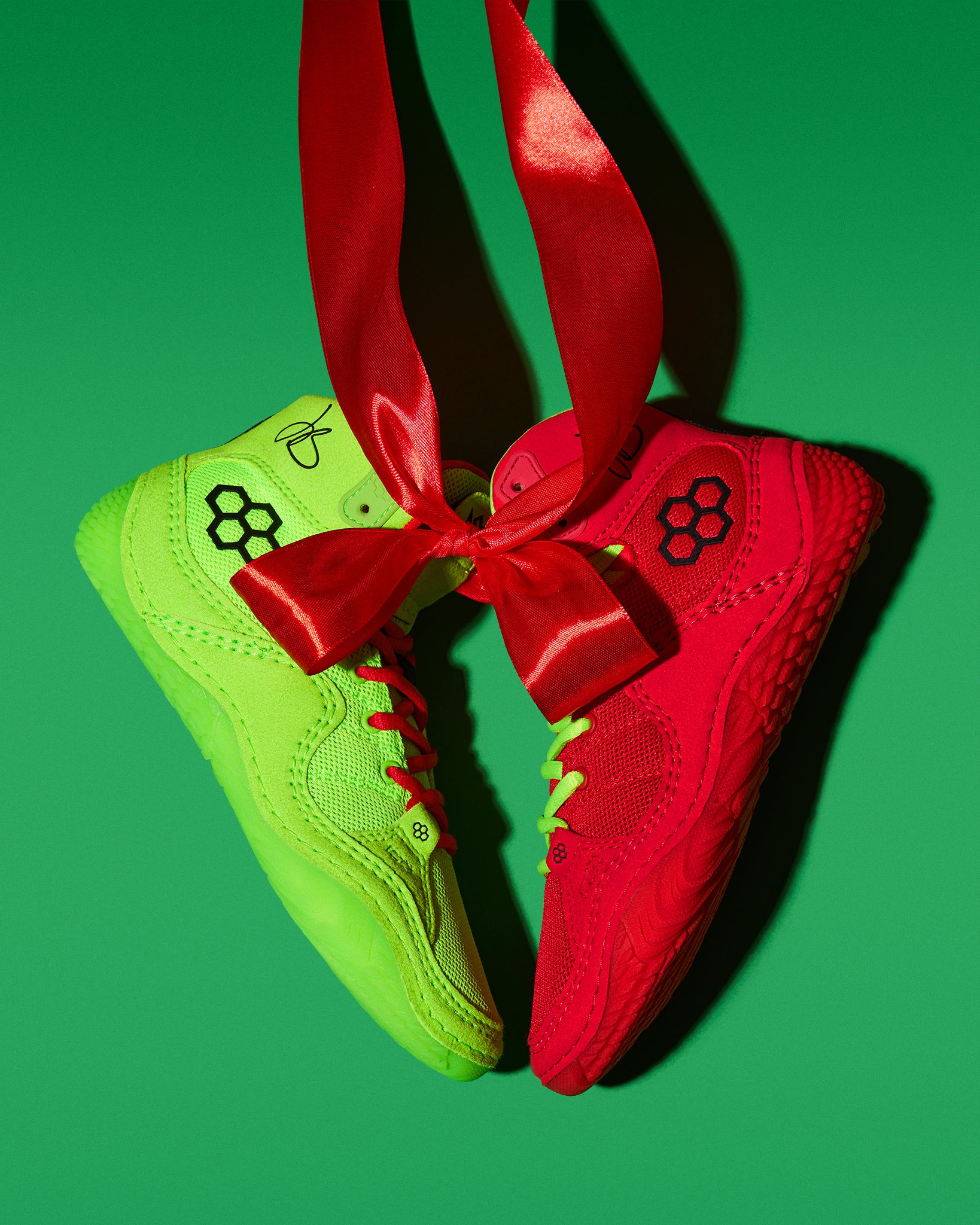 Green and red Wrestling shoes with a red ribbon on a green background