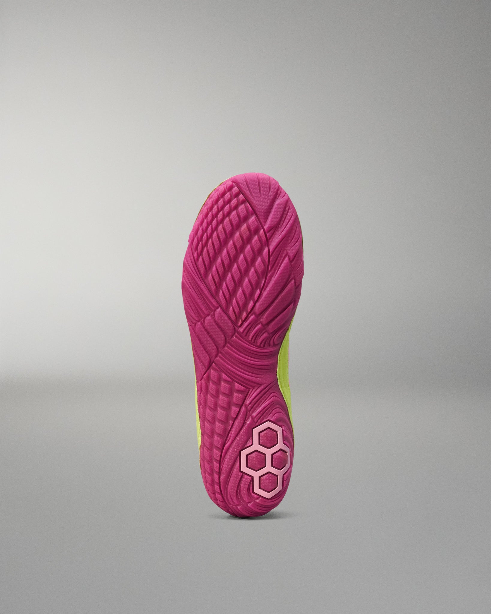 Close-up of a pink Wrestling shoe sole with a textured pattern on a gray background