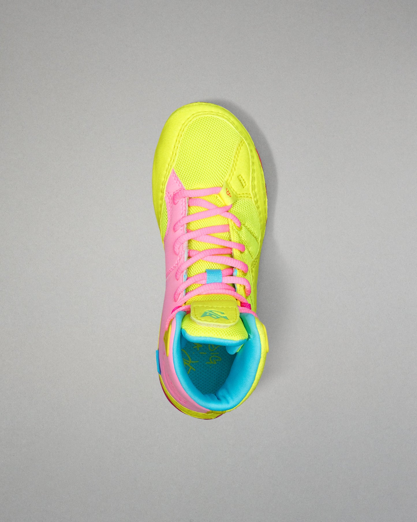Neon yellow Wrestling shoe with pink laces on a gray background