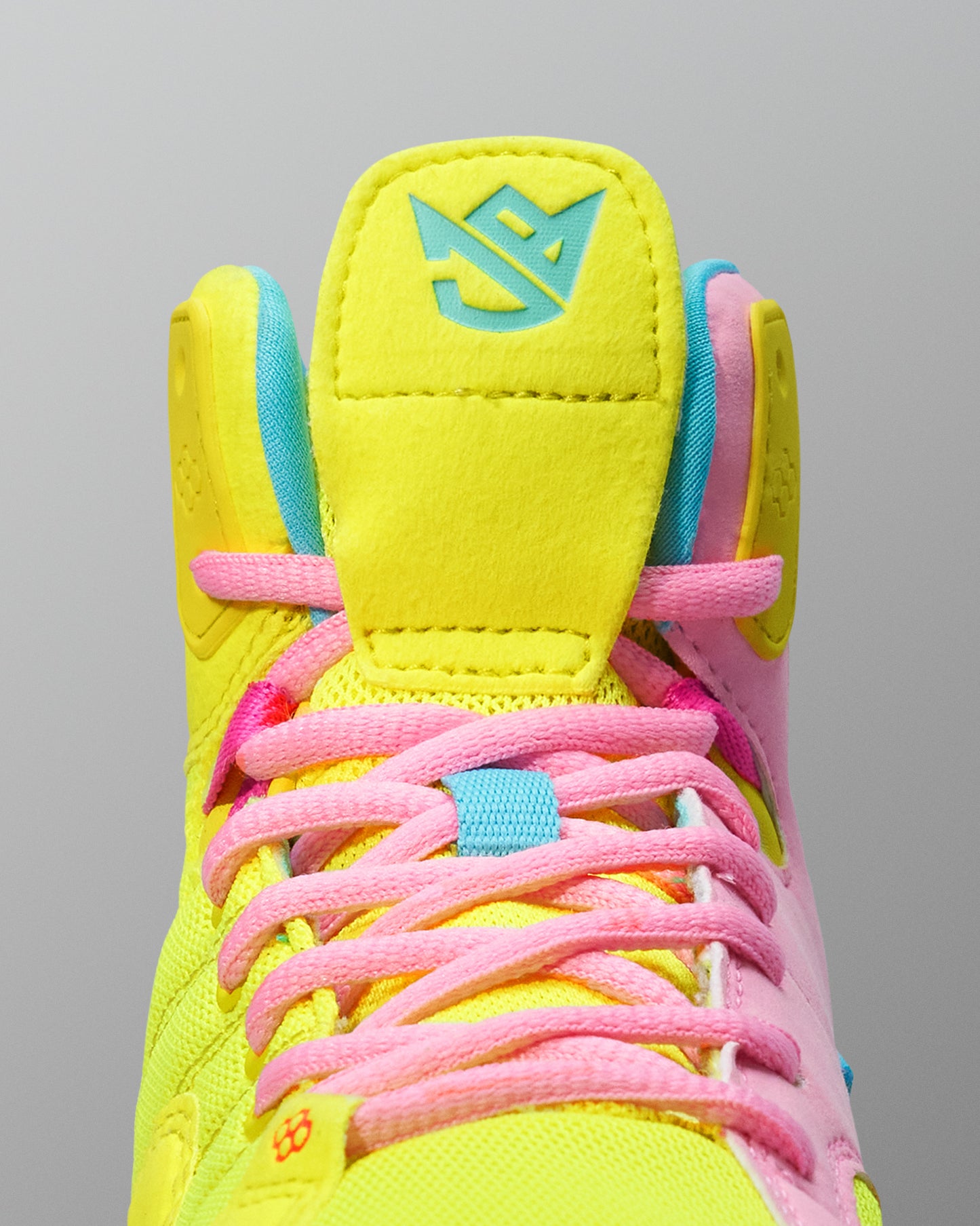 Brightly colored Wrestling shoe with pink laces on a gray background