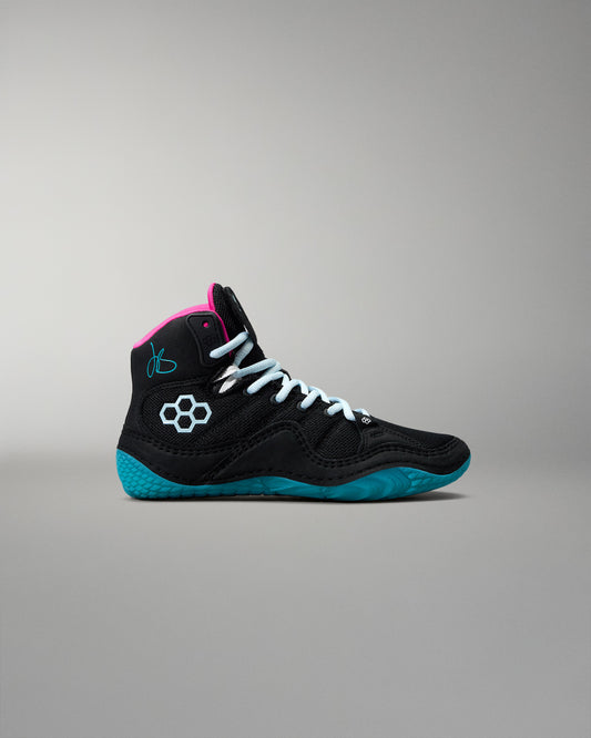 Black high-top wrestling shoe with pink accents and blue soles on a gray background