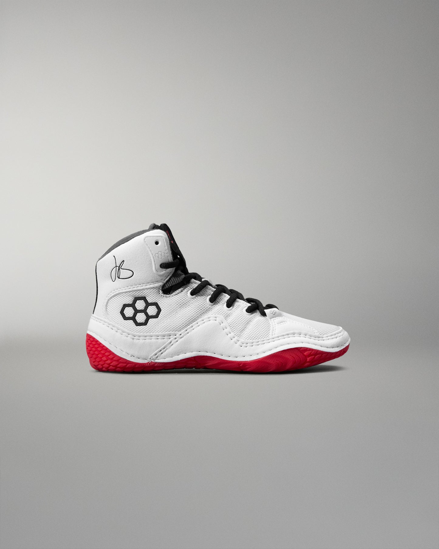 White wrestling shoe with red soles on a gray background
