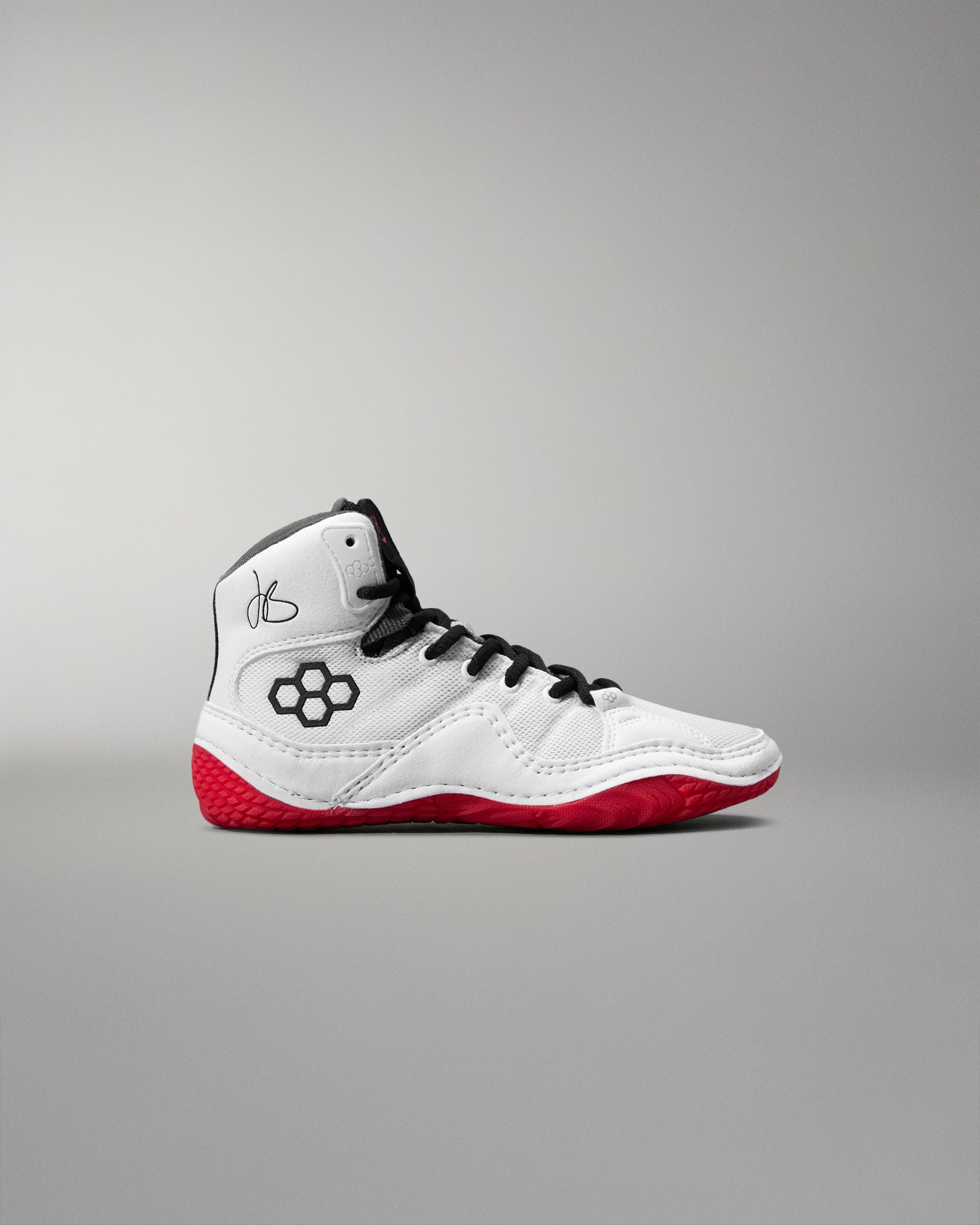 White wrestling shoe with red soles on a gray background