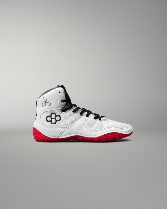 White wrestling shoe with red soles on a gray background