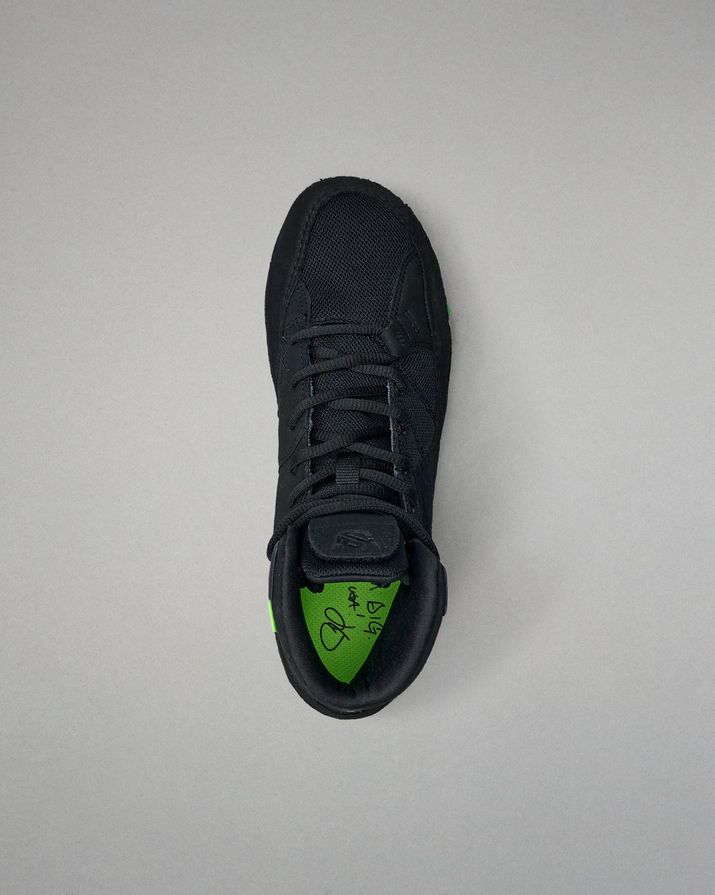 Black Wrestling shoe with green sole on a light gray background