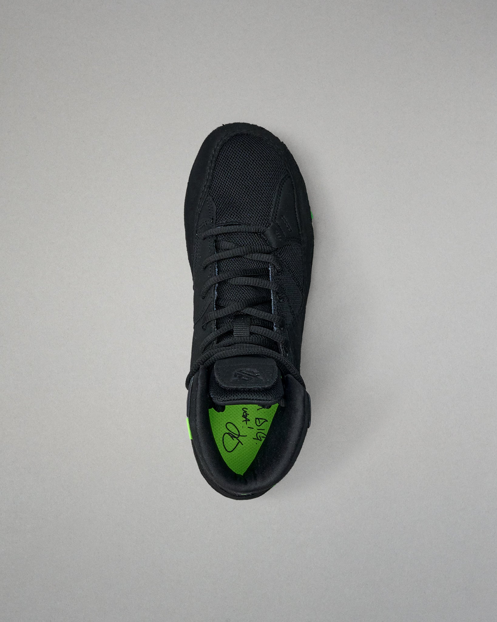 Black Wrestling shoe with green sole on a light gray background