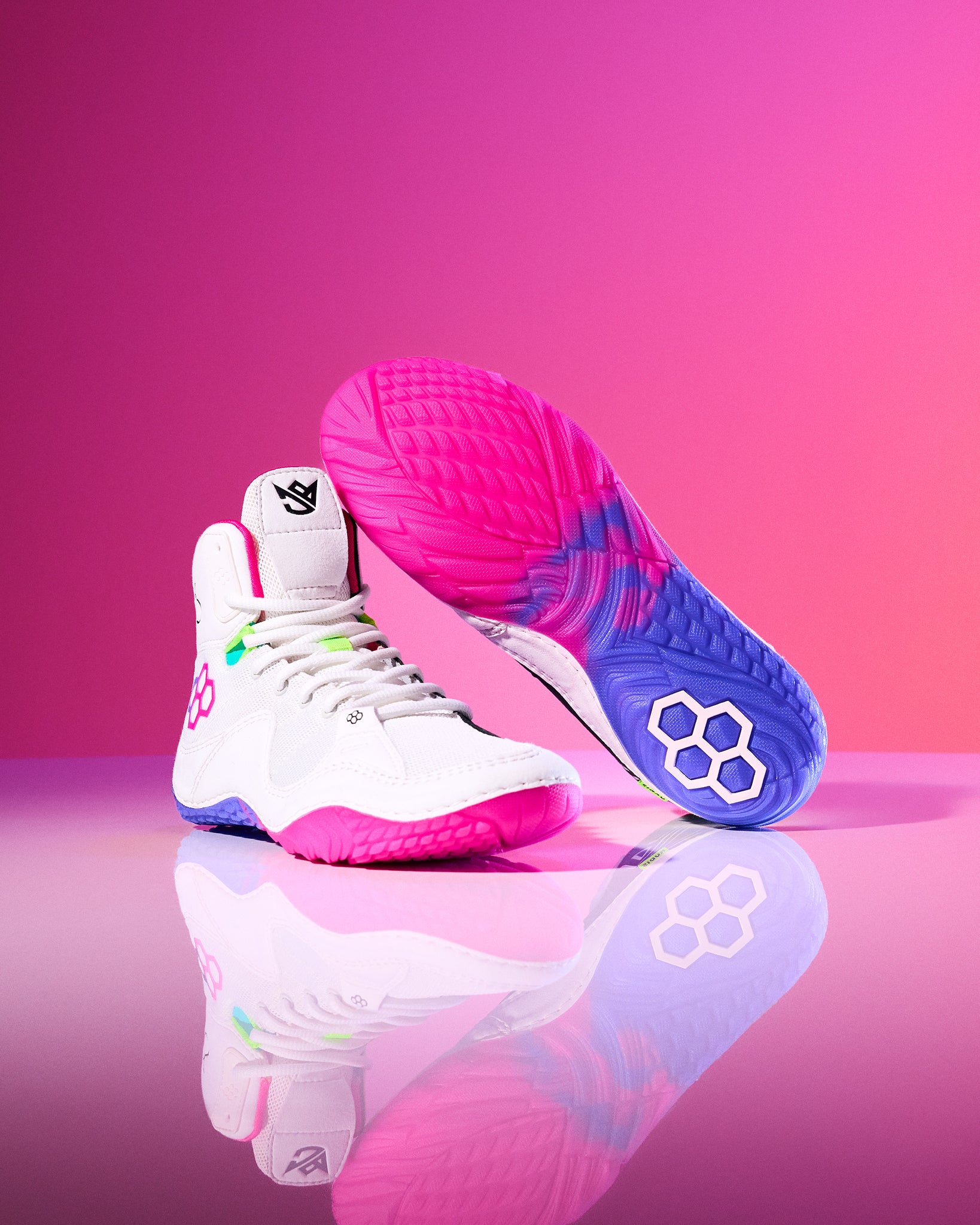 Colorful wrestling shoes on a pink gradient background