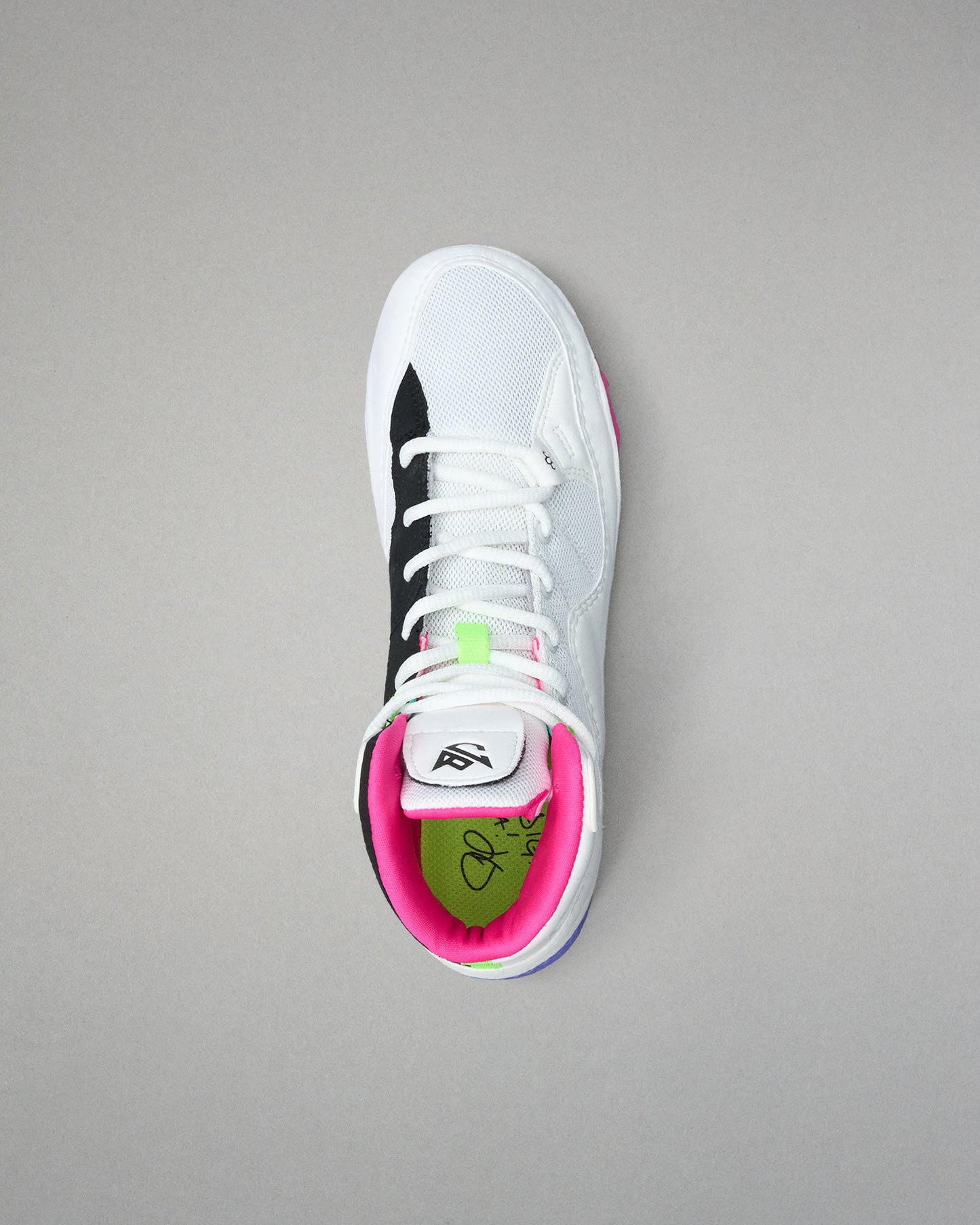 White wrestling shoe with black and pink accents on a gray background