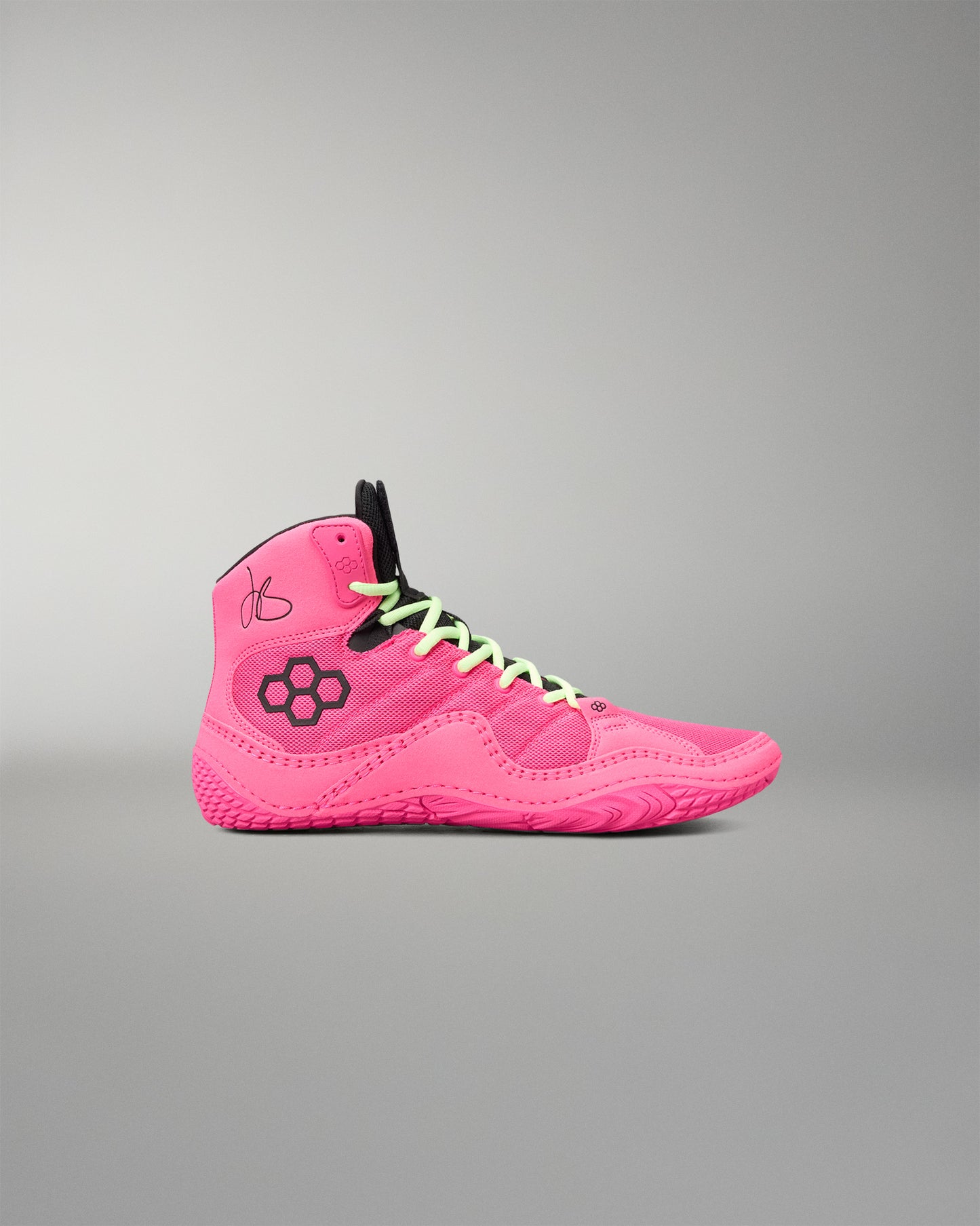 A bright pink high-top wrestling shoe with black accents, including a black floral logo on the side, black laces, and a black tongue, shown against a neutral gray background.