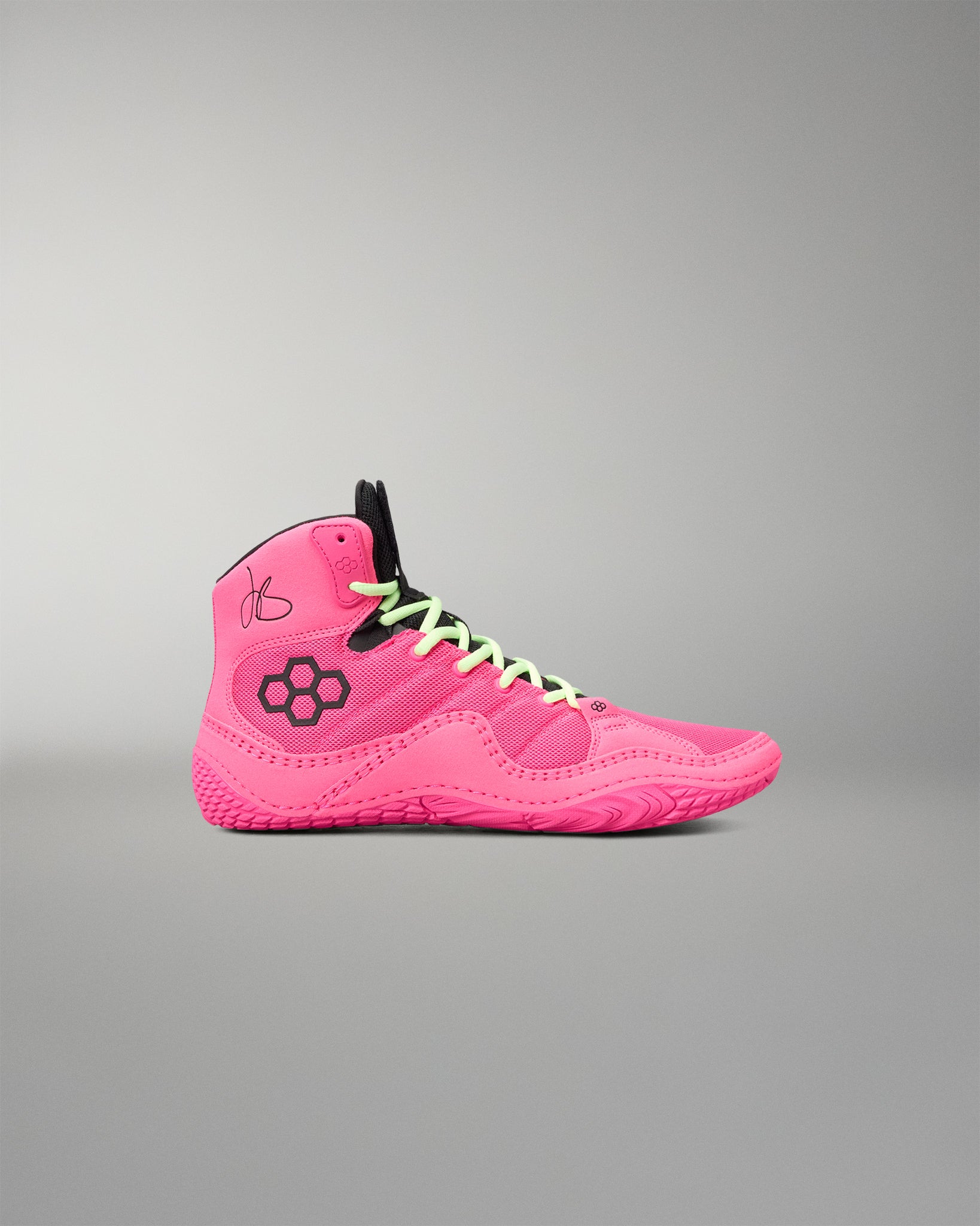 A bright pink high-top wrestling shoe with black accents, including a black floral logo on the side, black laces, and a black tongue, shown against a neutral gray background.