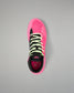A single high-top wrestling shoe shown from a top-down view on a neutral gray background. The shoe features a vibrant hot pink upper and sole, black overlays, neon yellow-green laces, and a black collar.