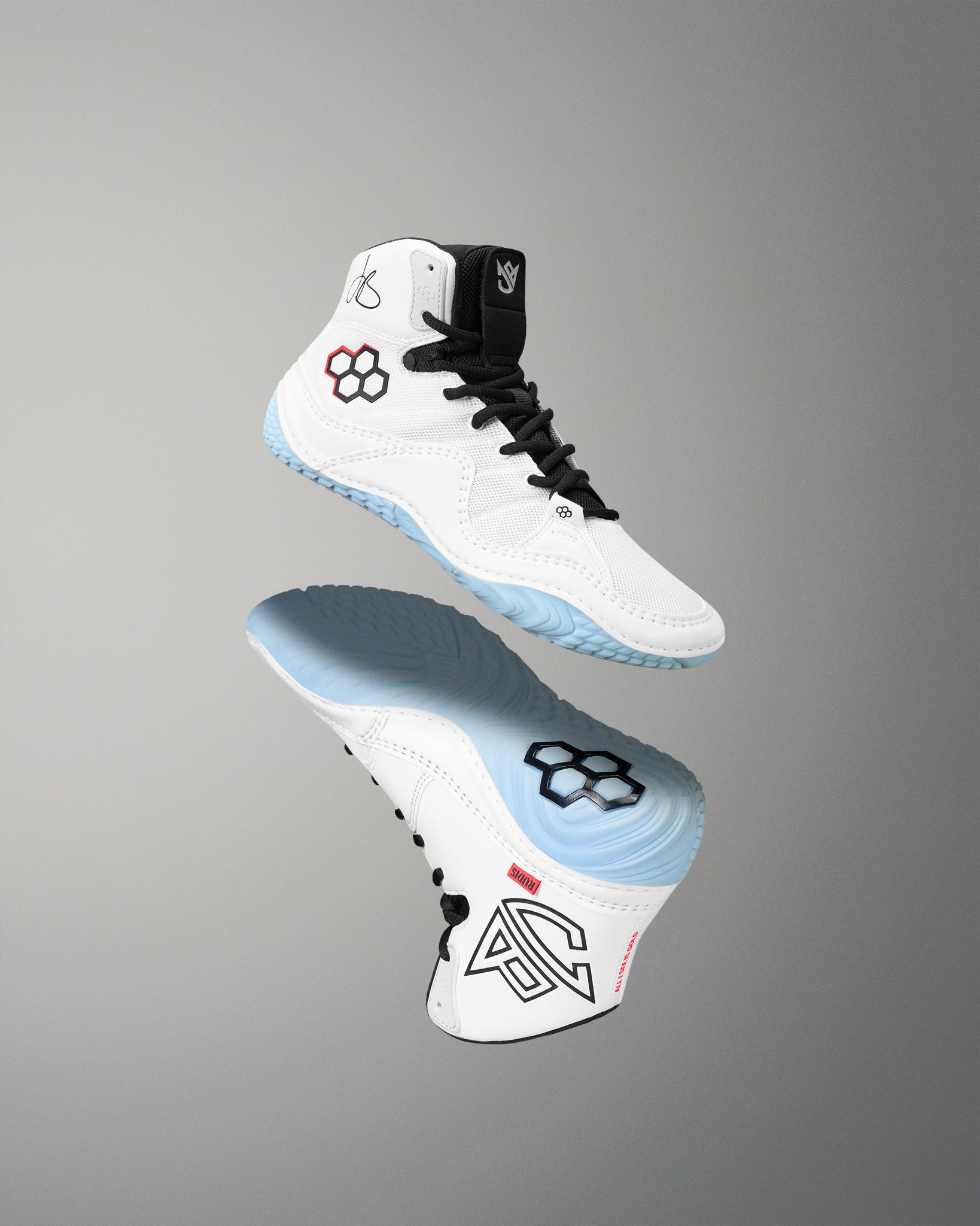A pair of high-top athletic wrestling shown floating against a smooth gray gradient background, displaying both the white upper with black laces and the light blue and black sole.