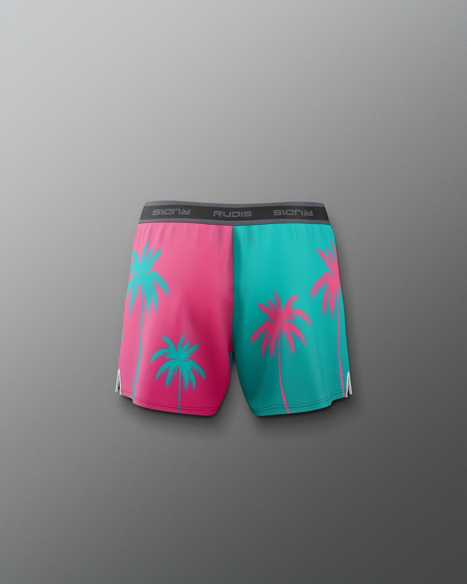 Pink and teal shorts with palm tree design on a gray background