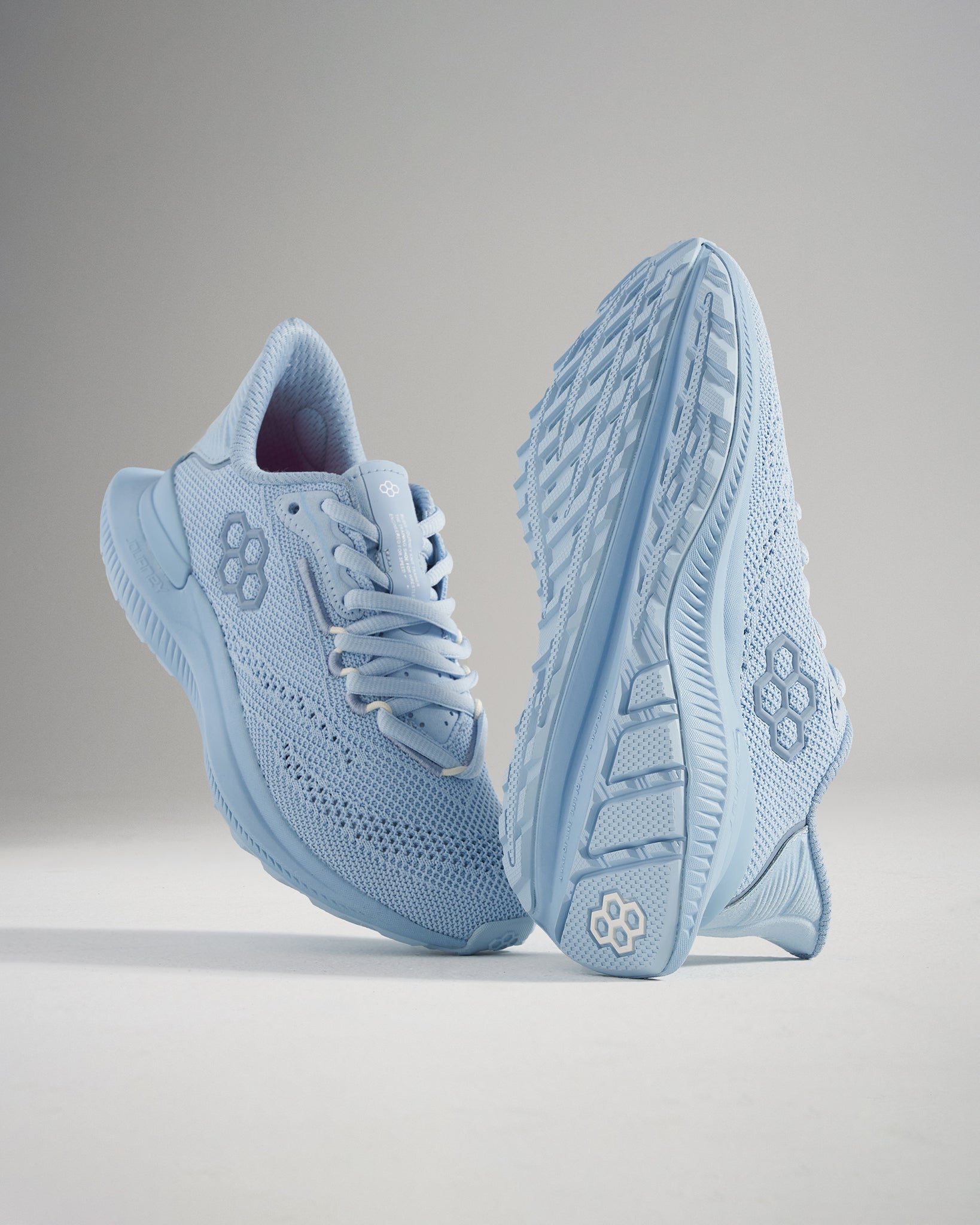 A pair of light blue athletic shoes featuring a breathable mesh upper and a textured sole for enhanced grip and support