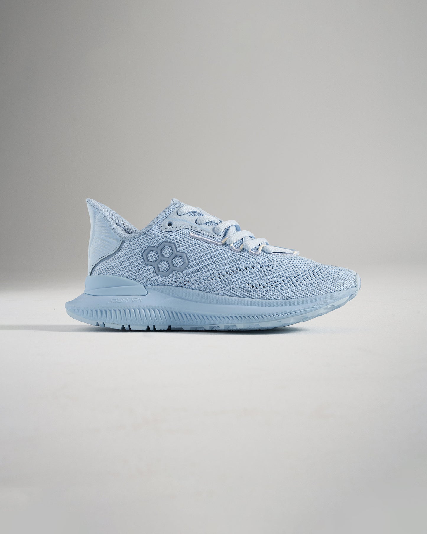 A light blue athletic shoe featuring a breathable mesh upper patterned detailing and a cushioned sole for comfort and performance