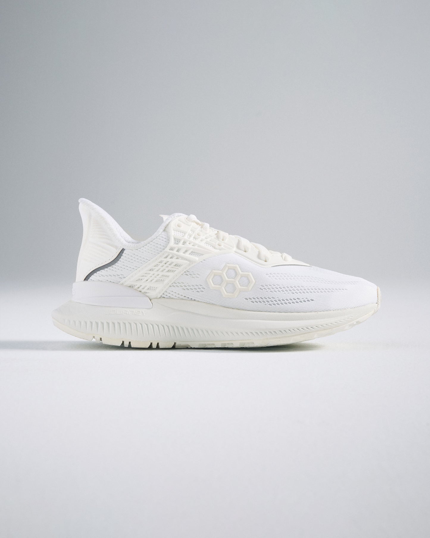 A sleek white athletic shoe featuring a breathable mesh upper textured sole and modern design elements for performance and style