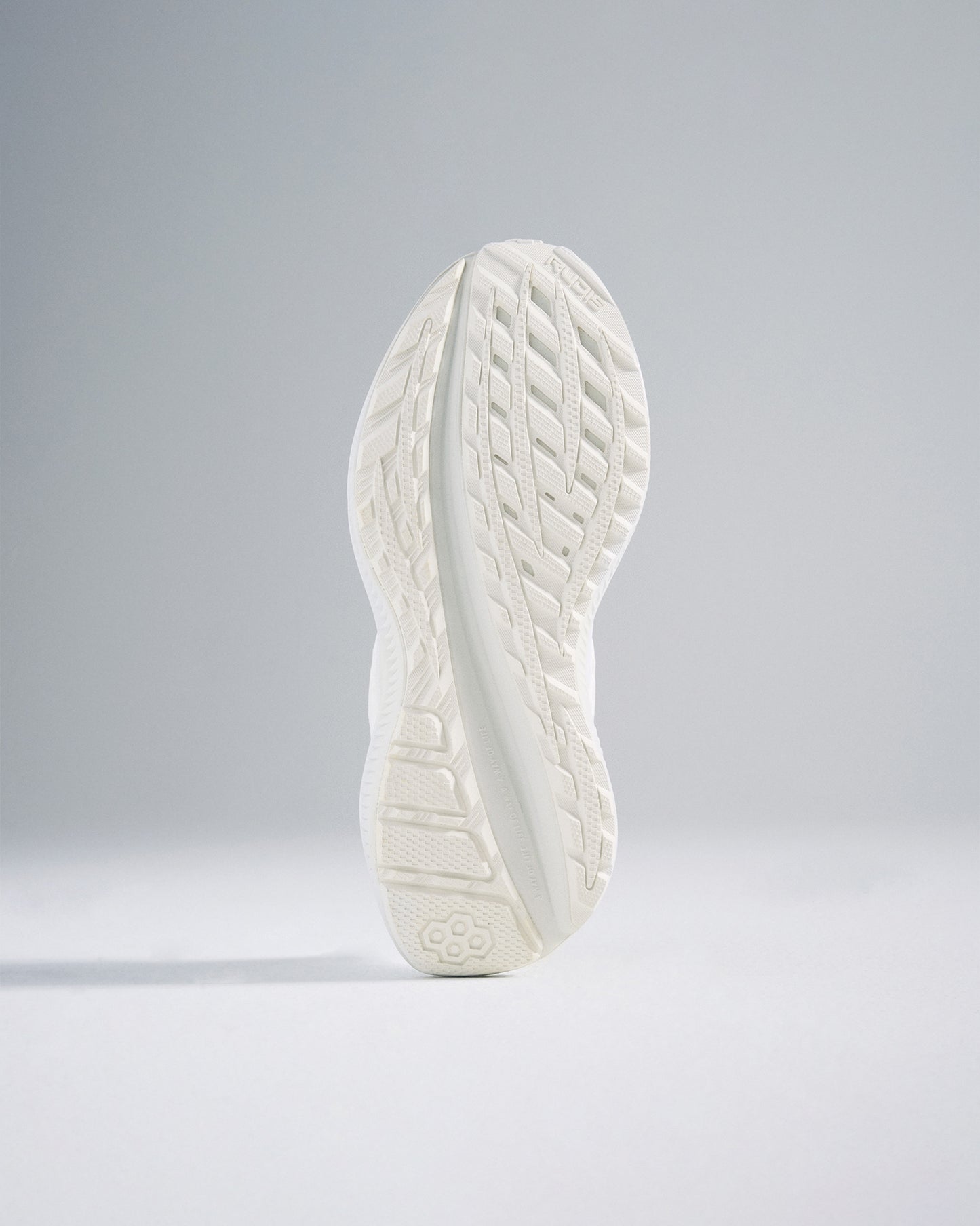 A close-up view of a sleek white athletic shoe sole featuring a detailed tread pattern for enhanced grip and performance
