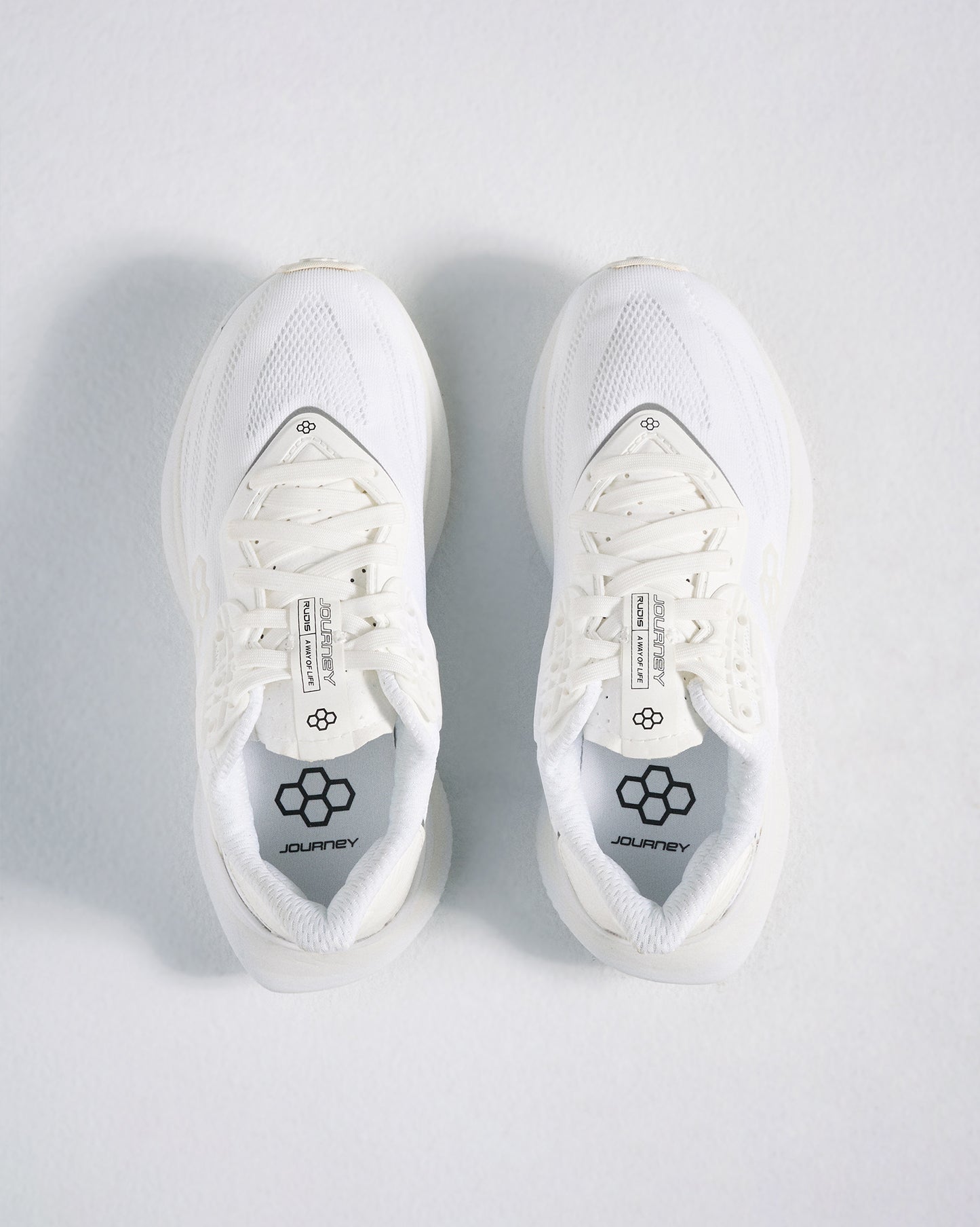 A pair of modern white athletic shoes featuring breathable mesh uppers and comfortable insoles designed for both style and performance