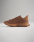 A side view of a modern brown athletic shoe featuring a breathable mesh upper and a textured sole designed for performance