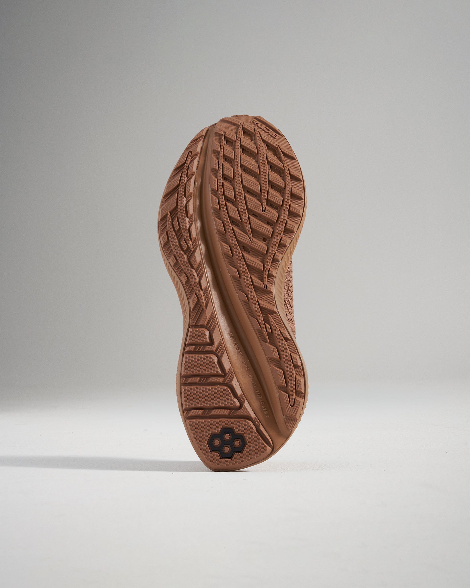 A close-up view of the sole of a running shoe featuring a textured surface designed for traction and grip with a shoe design that indicates durability