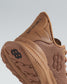 A close-up view of a brown athletic shoe featuring a breathable mesh design textured sole and branding elements that emphasize its functionality and style