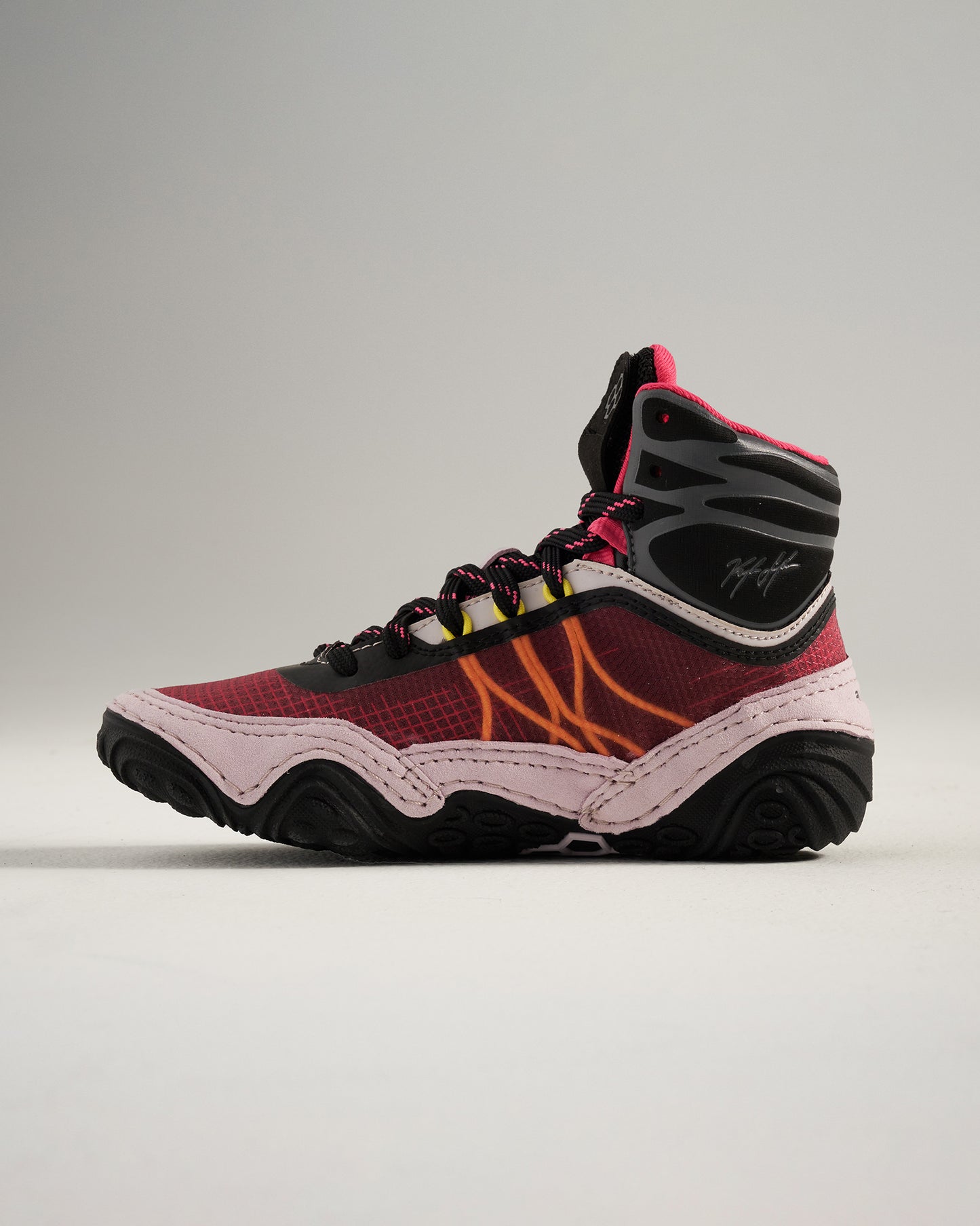 A stylish high-top athletic shoe featuring a bold red and black design with unique yellow and orange accents ideal for sports and casual wear