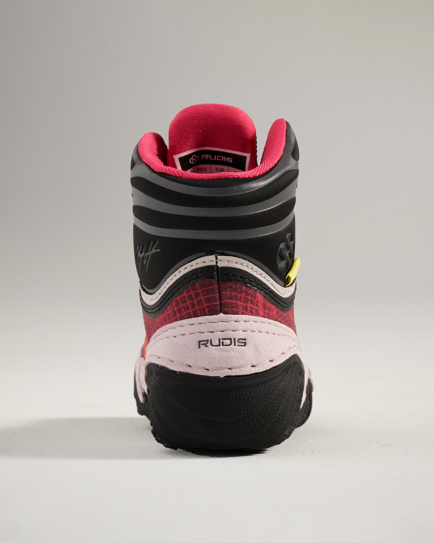 This image depicts the back view of a pair of wrestling shoes featuring a sleek design with a mix of black red and pink colors