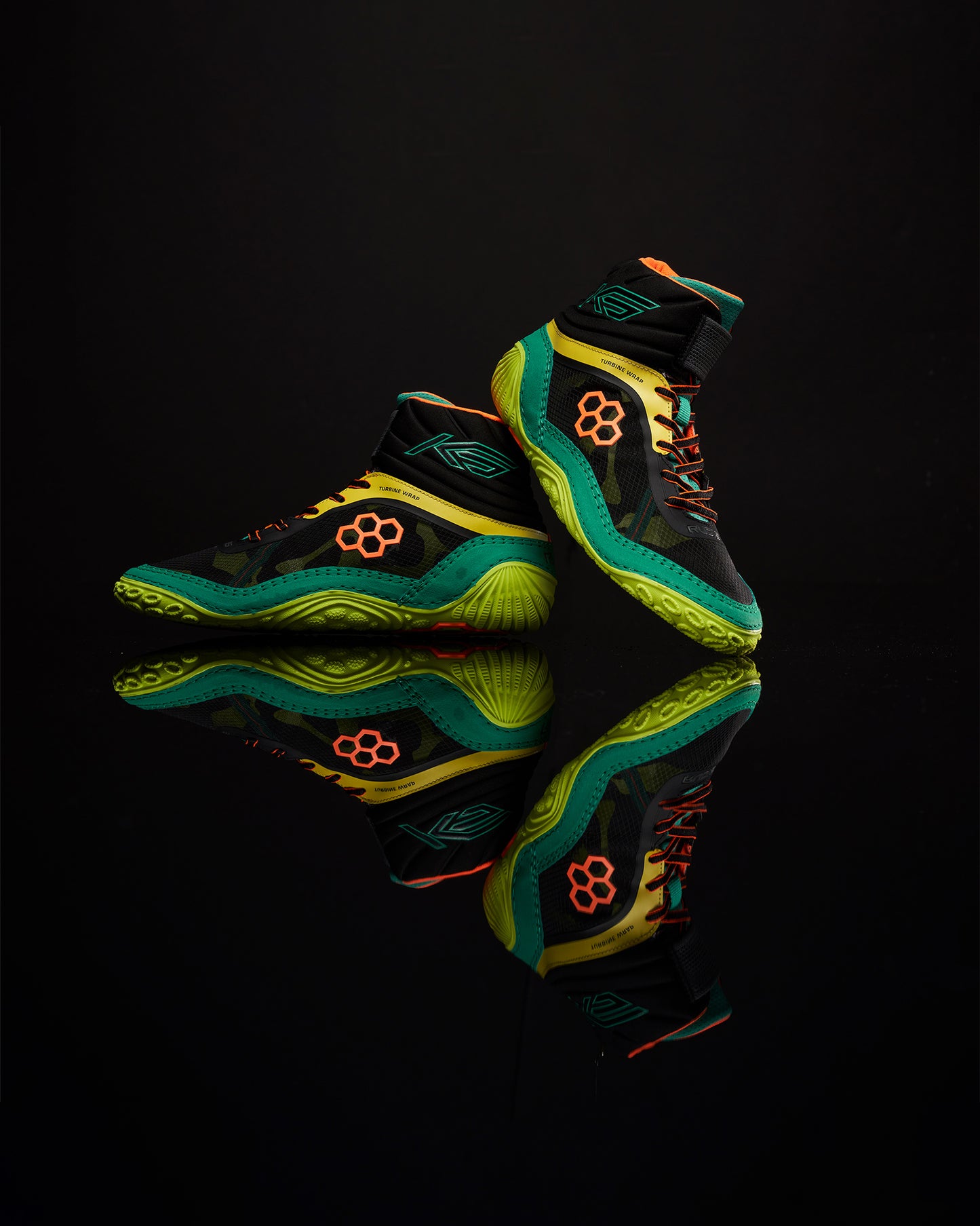 A pair of high-performance black basketball shoes with vibrant green and orange accents featuring a textured sole and unique design elements