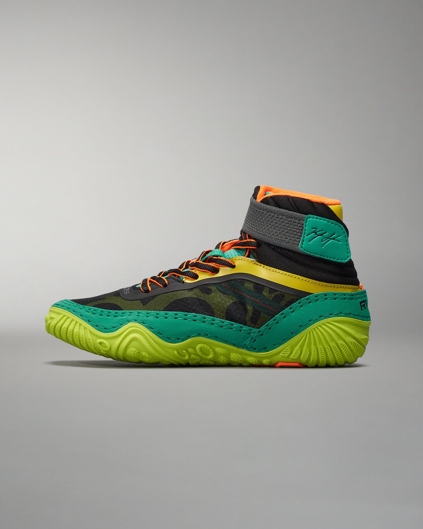 A vibrant high-top athletic shoe combines black green and orange elements for a striking look