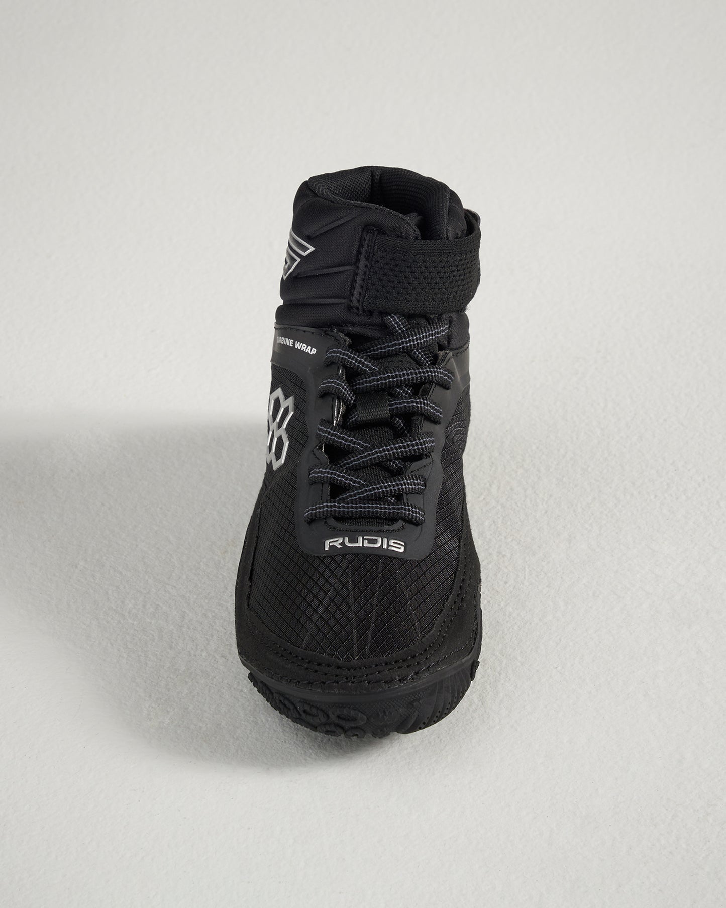 A top view of a sleek black wrestling shoe featuring intricate textures a high ankle support design and reflective branding