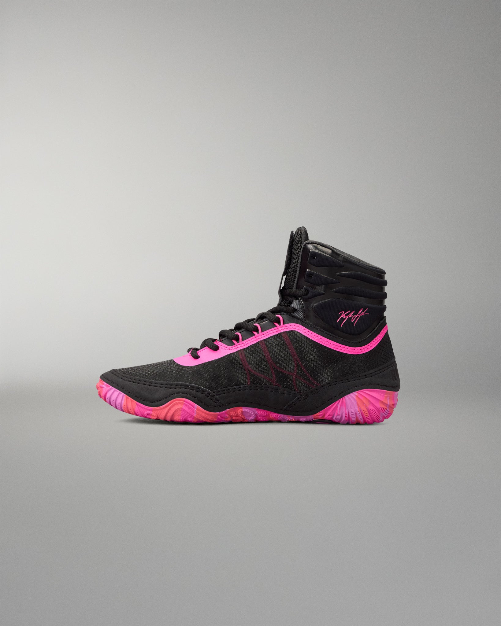 A high-top athletic wrestling shoe in black with vibrant neon pink accents on the laces, collar trim, and sole, shown in profile against a neutral gray background.