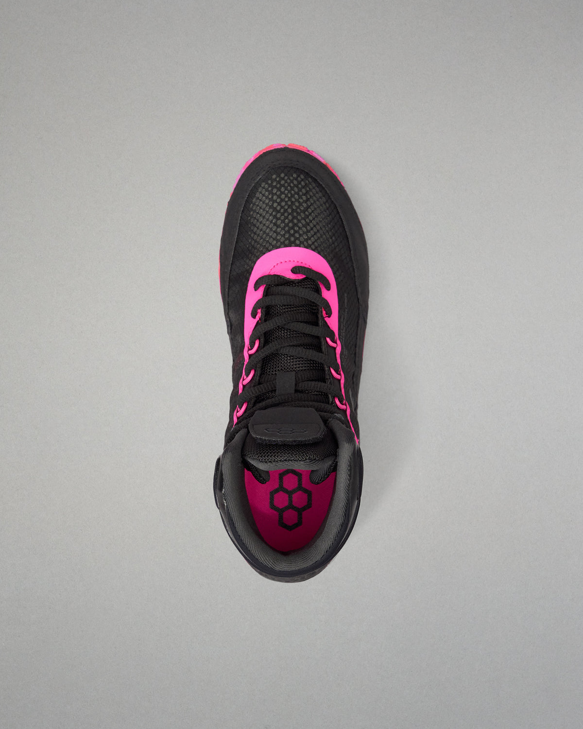 A black athletic wrestling shoe with vibrant hot pink accents, shown from a top-down view on a neutral gray background.